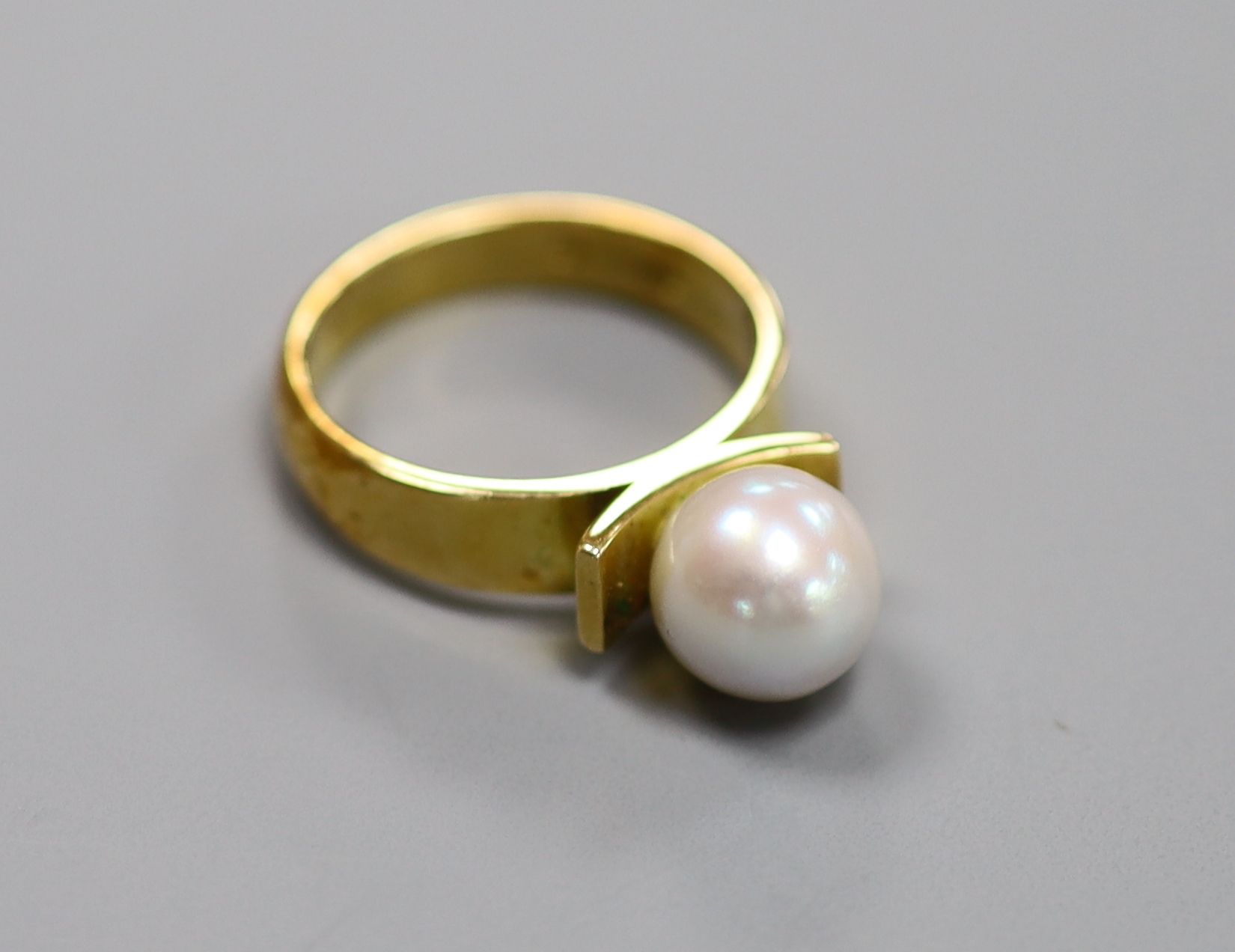 A modern 18ct and cultured pearl set dress ring, size M/N